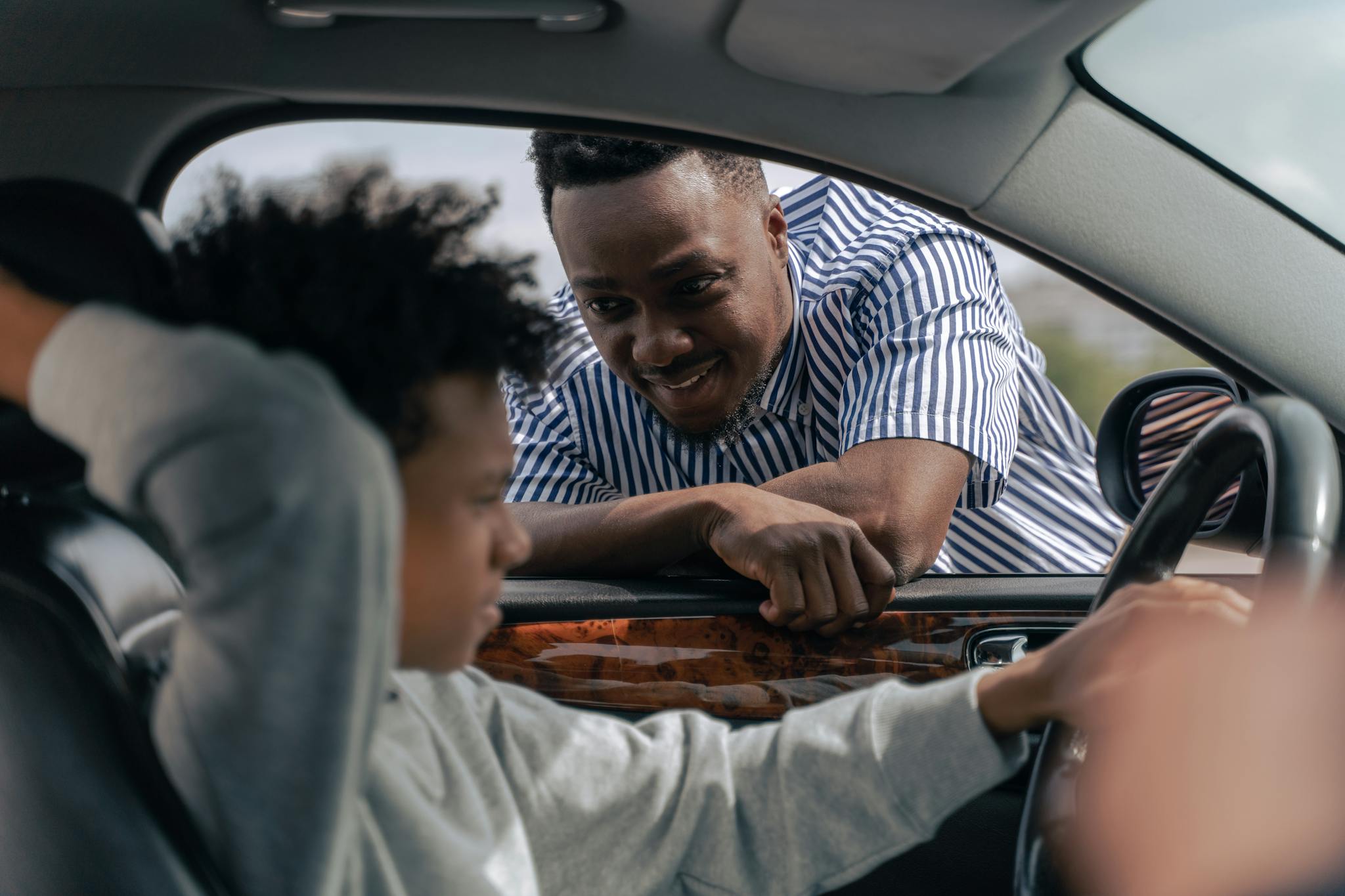 Father teaching his son how to drive, bonding and learning together.